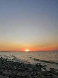 Scenic view of sea against clear sky during sunset