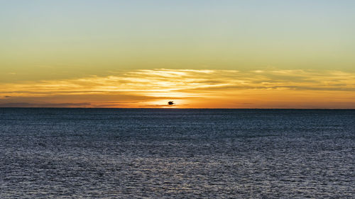 Scenic view of sea against orange sky