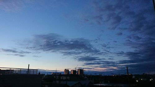 Silhouette buildings against sky at dusk