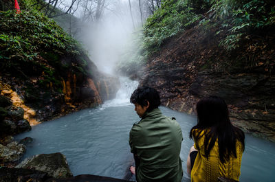 Rear view of friends against waterfall