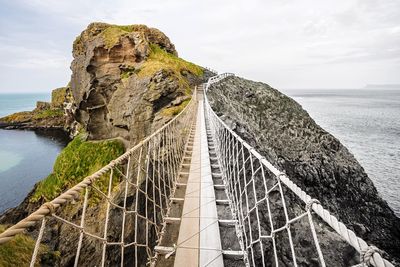 Scenic view of rocks by sea against sky