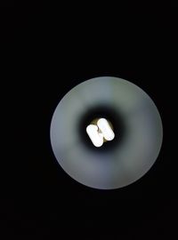 Close-up of light bulb against black background