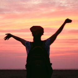 Silhouette of person standing on beach during sunset