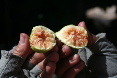 Close-up of hand holding halved fig