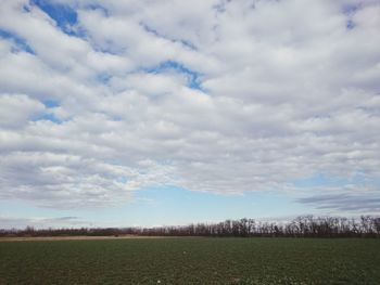 Scenic view of field against cloudy sky