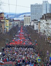 Crowd in city against sky