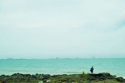 People standing on beach against sky