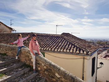 People on roof of building against sky