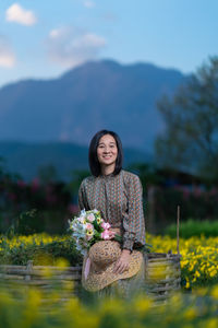 Portrait of a smiling young woman against lake