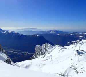 Scenic view of snowcapped mountains against clear blue sky