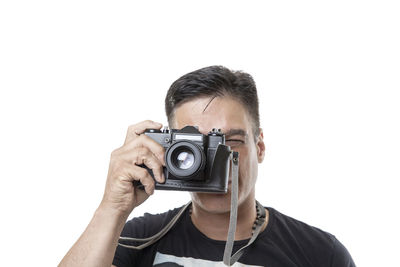 Portrait of man photographing against white background