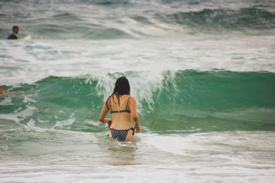 Rear view of man surfing in sea