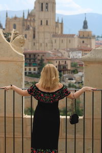 Rear view of woman standing against buildings