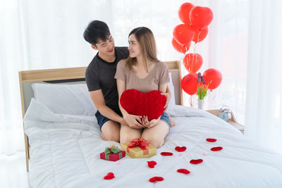 Rear view of women walking with heart shape on bed