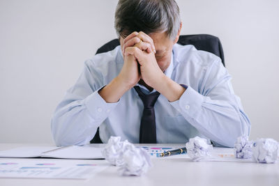 Depressed businessman sitting at desk in office