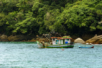 Fishing boat between the rain forest and sea