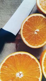 High angle view of halved oranges with knife on table