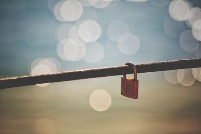 Close-up of padlocks hanging on metal against sky