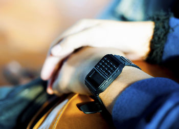 Midsection of person wearing keypad wristwatch