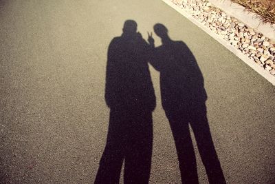 Shadow of man and woman standing on tiled floor