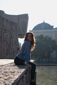 Portrait of woman sitting against sky
