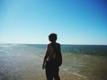 Man looking at sea against clear sky