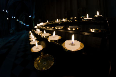 5 rows of prayer candles run from right to left in this wide angle photo from a cathedral