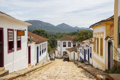 Houses by mountains against sky