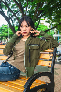 Portrait of young woman sitting on bench