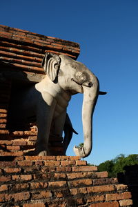 Low angle view of statue against blue sky