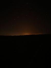 Silhouette landscape against sky at night