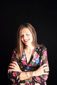 Young woman smiling against black background