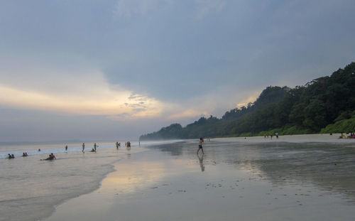People on beach against sky