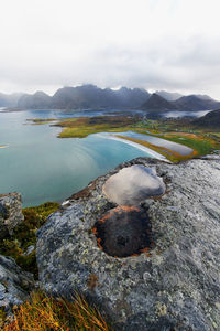 View of water on mountain top with beach and countryside in the background in lofoten norway