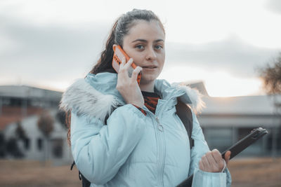 Side view of young woman using mobile phone