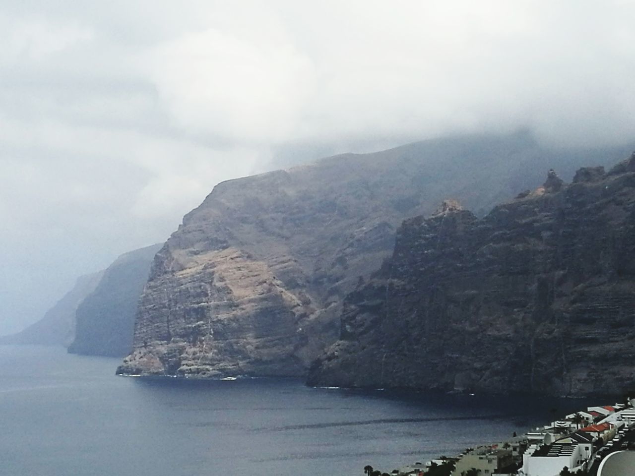 SCENIC VIEW OF ROCKY MOUNTAINS BY SEA AGAINST SKY