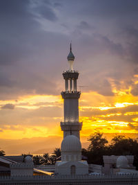 Mosque against cloudy sky during sunset