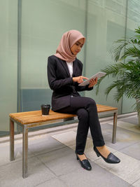 Full length of woman sitting on seat