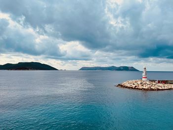 Lighthouse by sea against sky