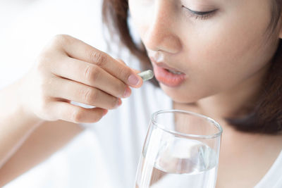 Close-up portrait of a woman drinking glass