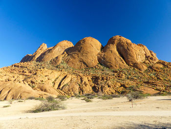 Rock formations in desert against clear blue sky