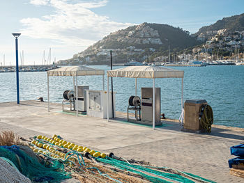 Empty gas station. fishing net in foreground, sea fishing port. port d'andratx, mallorca