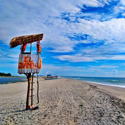 Lifeguard hut on beach against sky