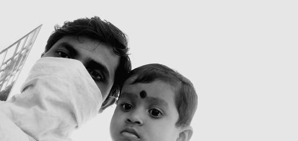 Portrait of father with daughter against clear sky