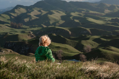 Young child overlooking green mountains in new zealand