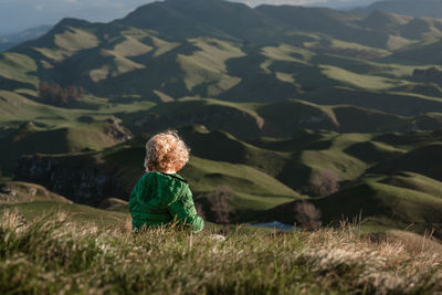 Young child overlooking green mountains in new zealand