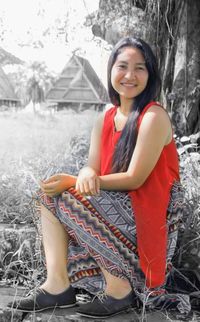 Portrait of smiling young woman sitting outdoors