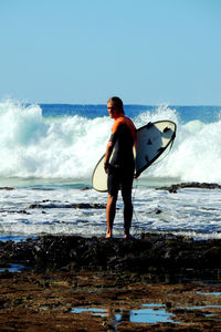 Full length of man standing on sea shore against sky