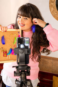 Portrait of young woman with camera