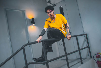 Portrait of young man sitting on staircase